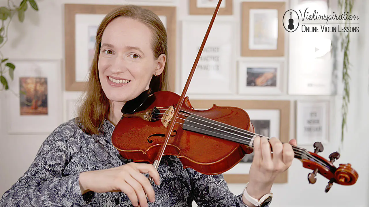 Julia smiling while playing the violin.