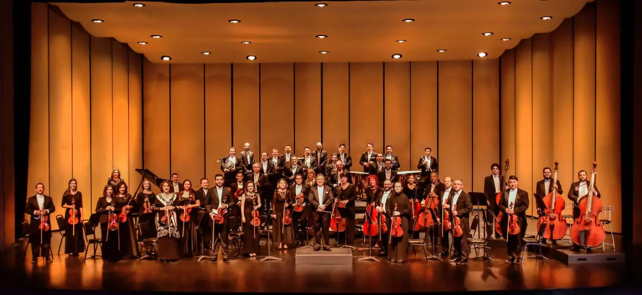 Orchestra musicians standing together with their instruments