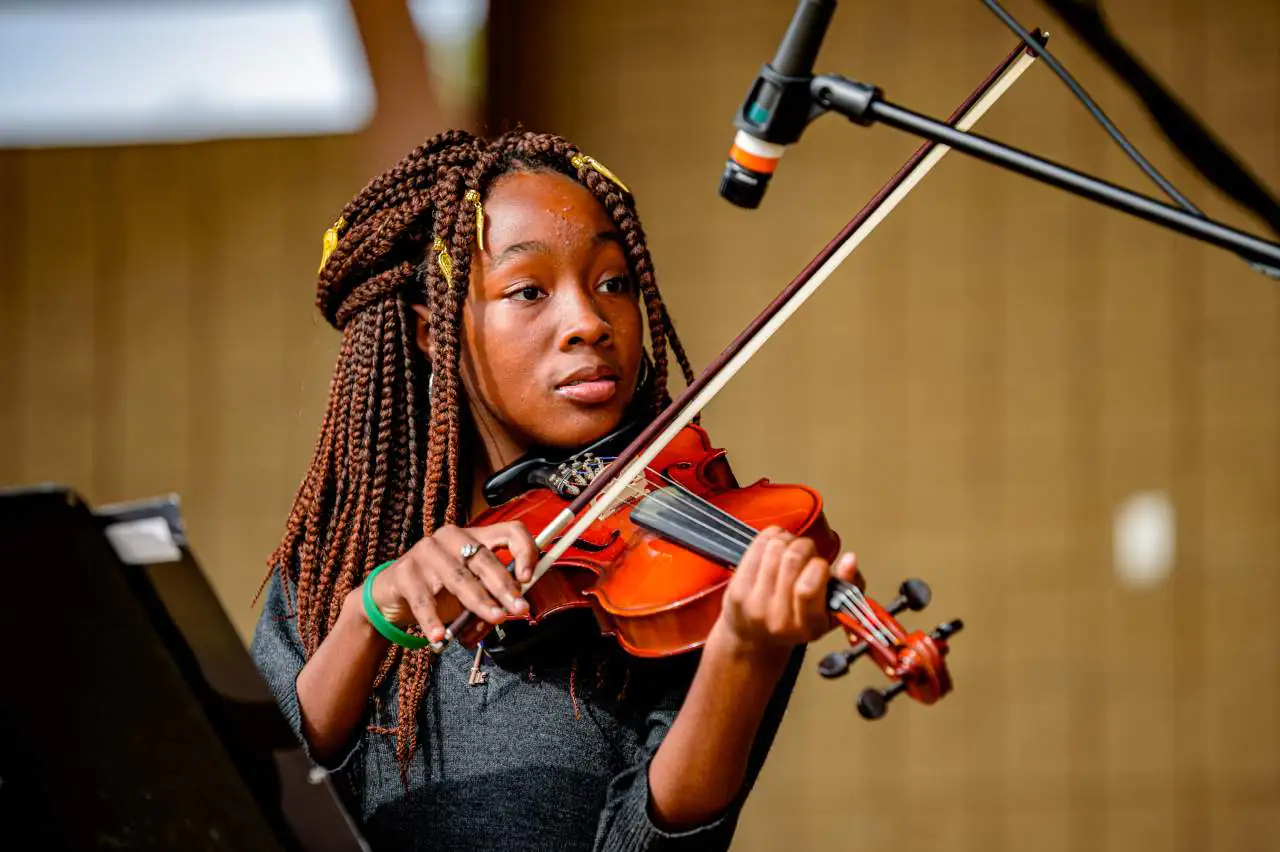 Teenage violinist performing at a youth arts festival