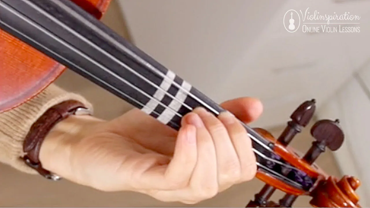 Close-up of a violinist practicing double stops to prepare left-hand finger placement across strings