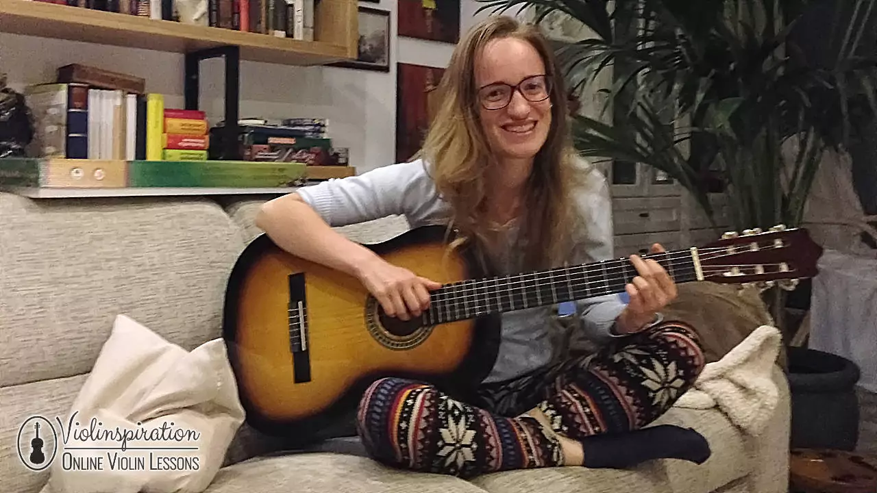 Woman playing an acoustic guitar with a round sound hole.